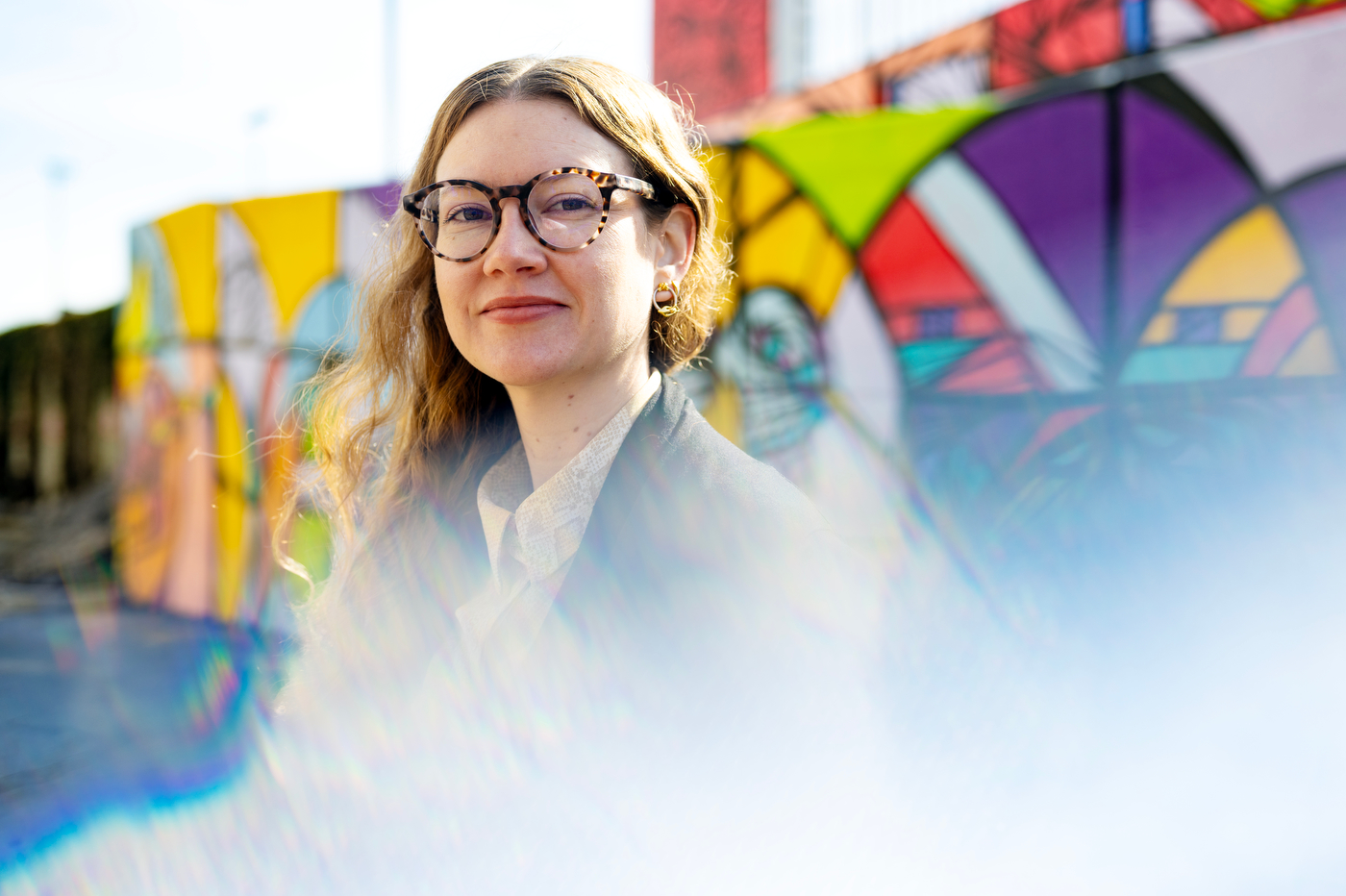 Portrait of a person in front of a colorful backdrop. 