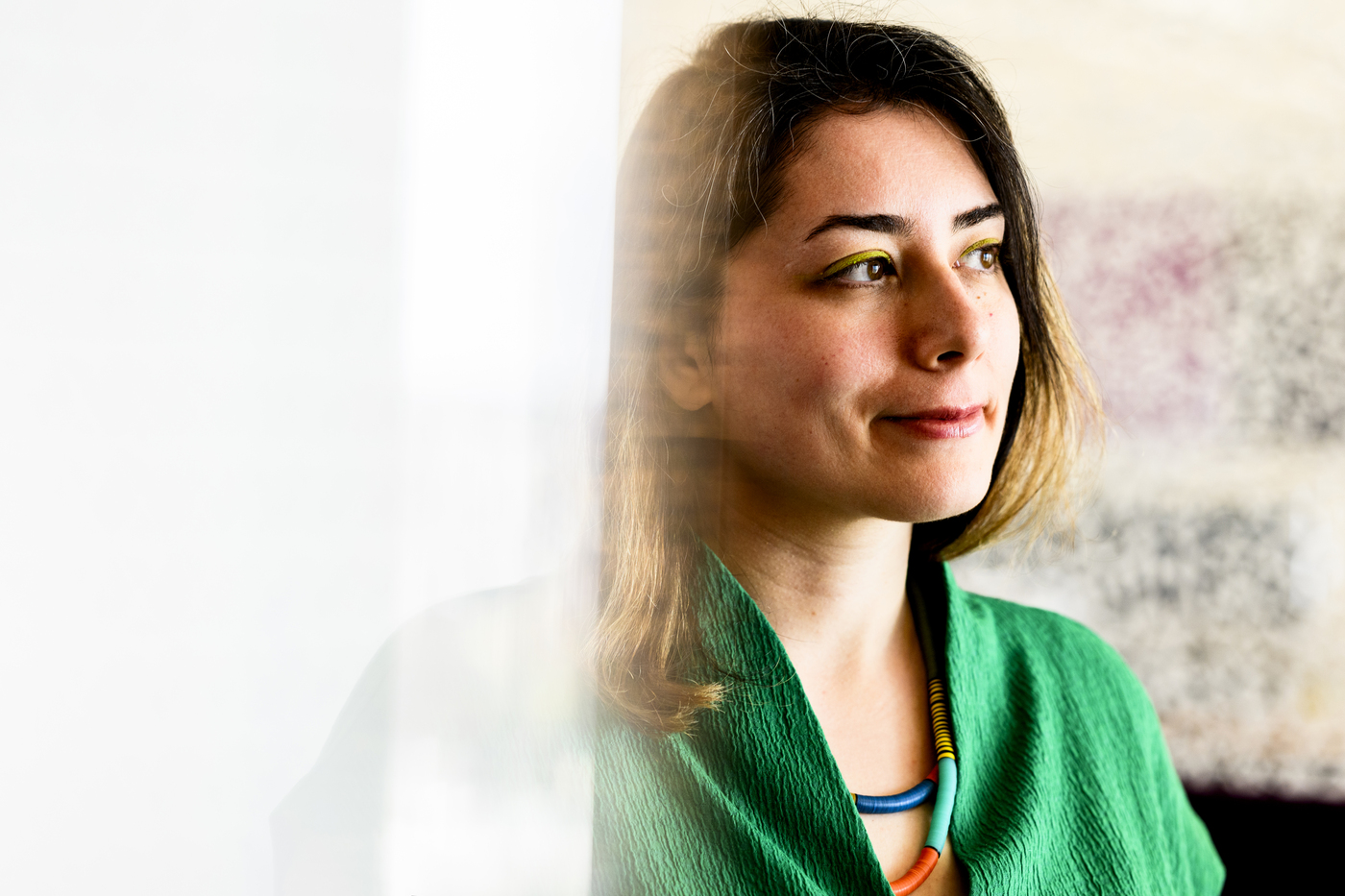 Portrait of Malihe Alikhani wearing a green shirt and looking thoughtfully off camera. 