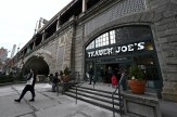 The outside of a stone building with a 'Trader Joe's' sign over the door in New York City.