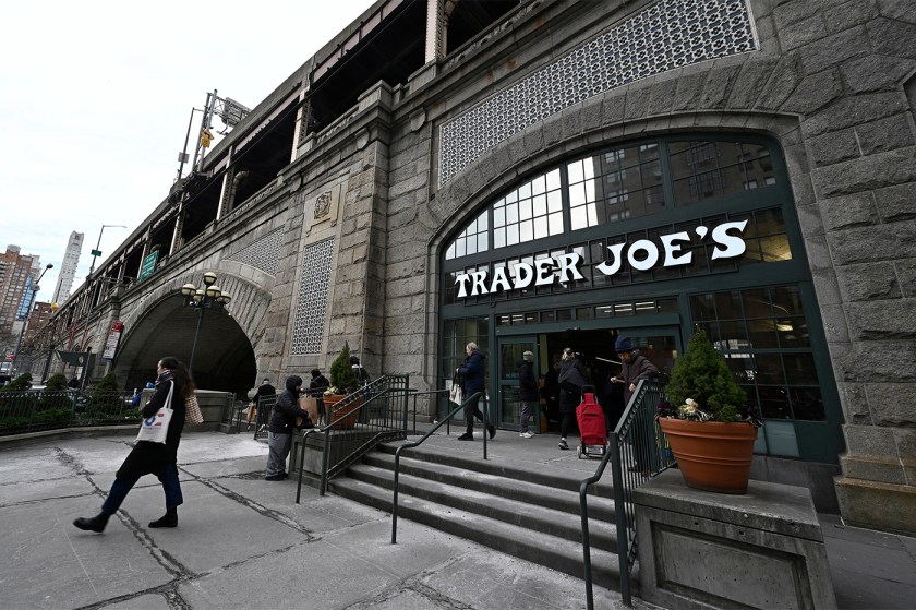 The outside of a stone building with a 'Trader Joe's' sign over the door in New York City.