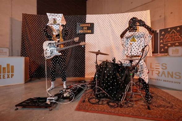 Canadian band Angine de Poitrine stand side by side in polka dotted costumes and papier mache headwear.