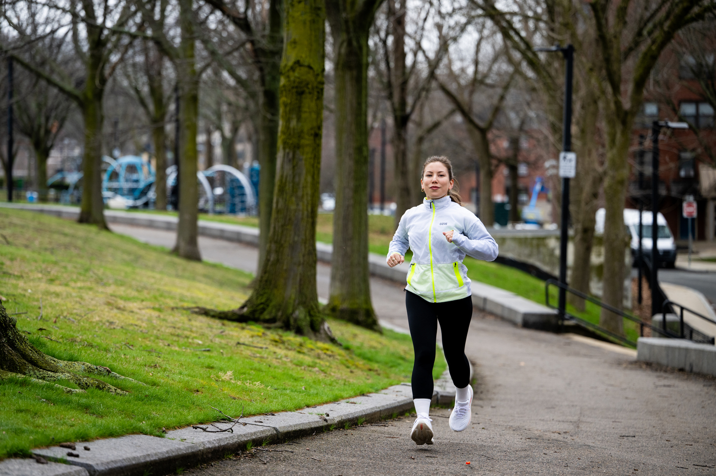 Megan Doe runs outside on a paved path