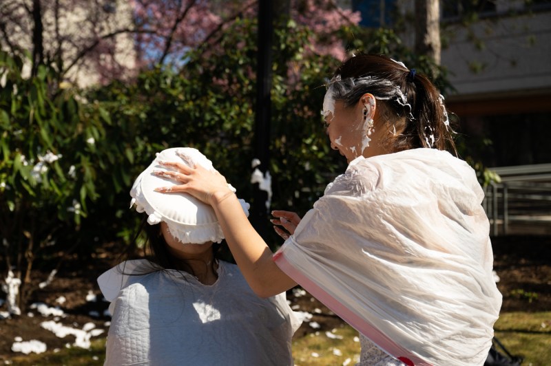 A person getting a pie smashed into their face during a Kappa Phi Lambda sorority fundraiser for CARE on Northeastern's Boston campus.