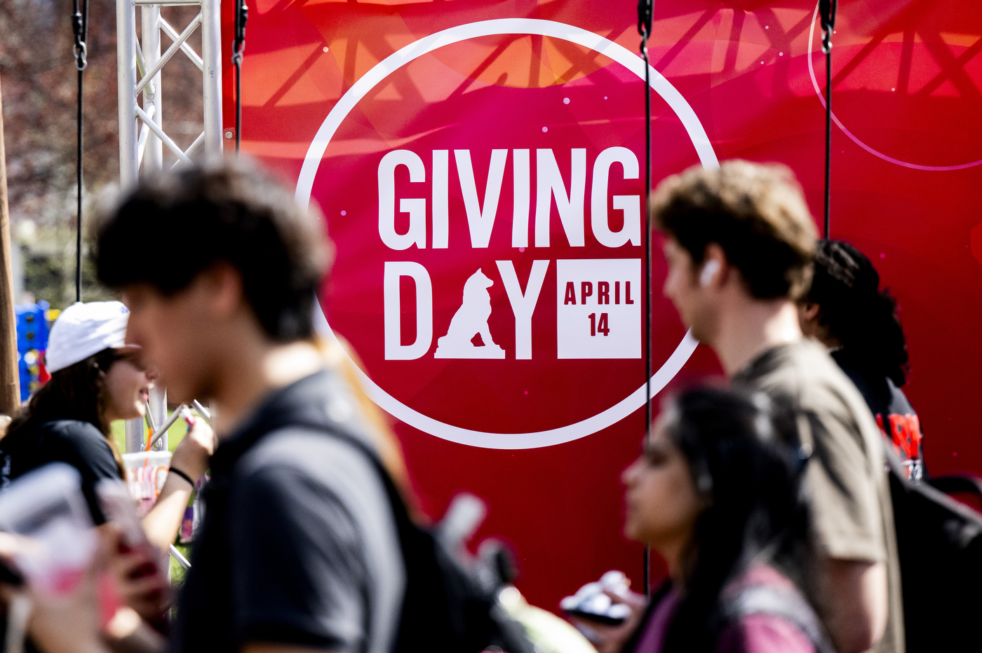 Students walk by a Giving Day sign on campus. 