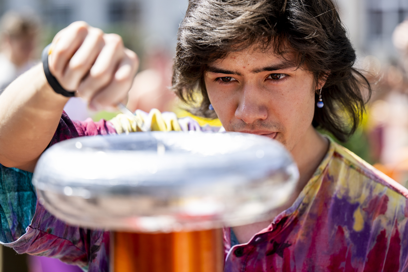 A student concentrates while playing a ring toss game on campus. 