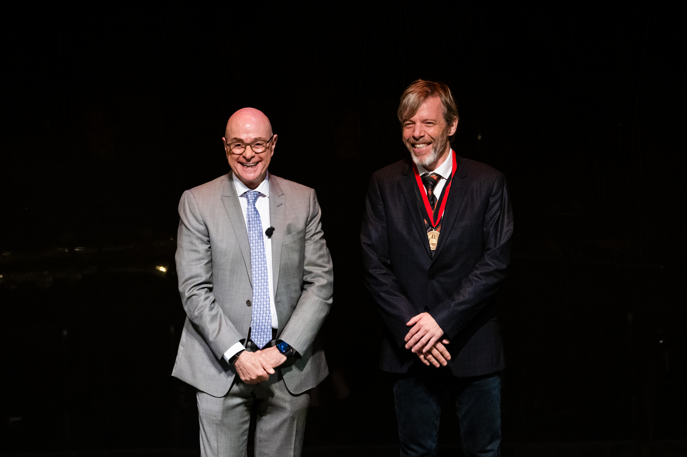 President Aoun and Koen Pauwels posing on stage at the Academic Honors Convocation. 