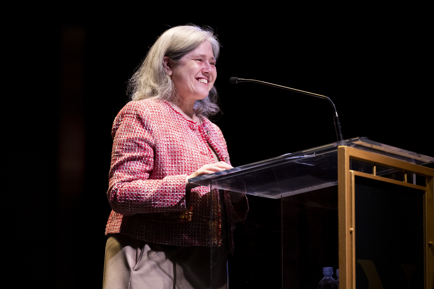 A smiling speaker talks at a podium.