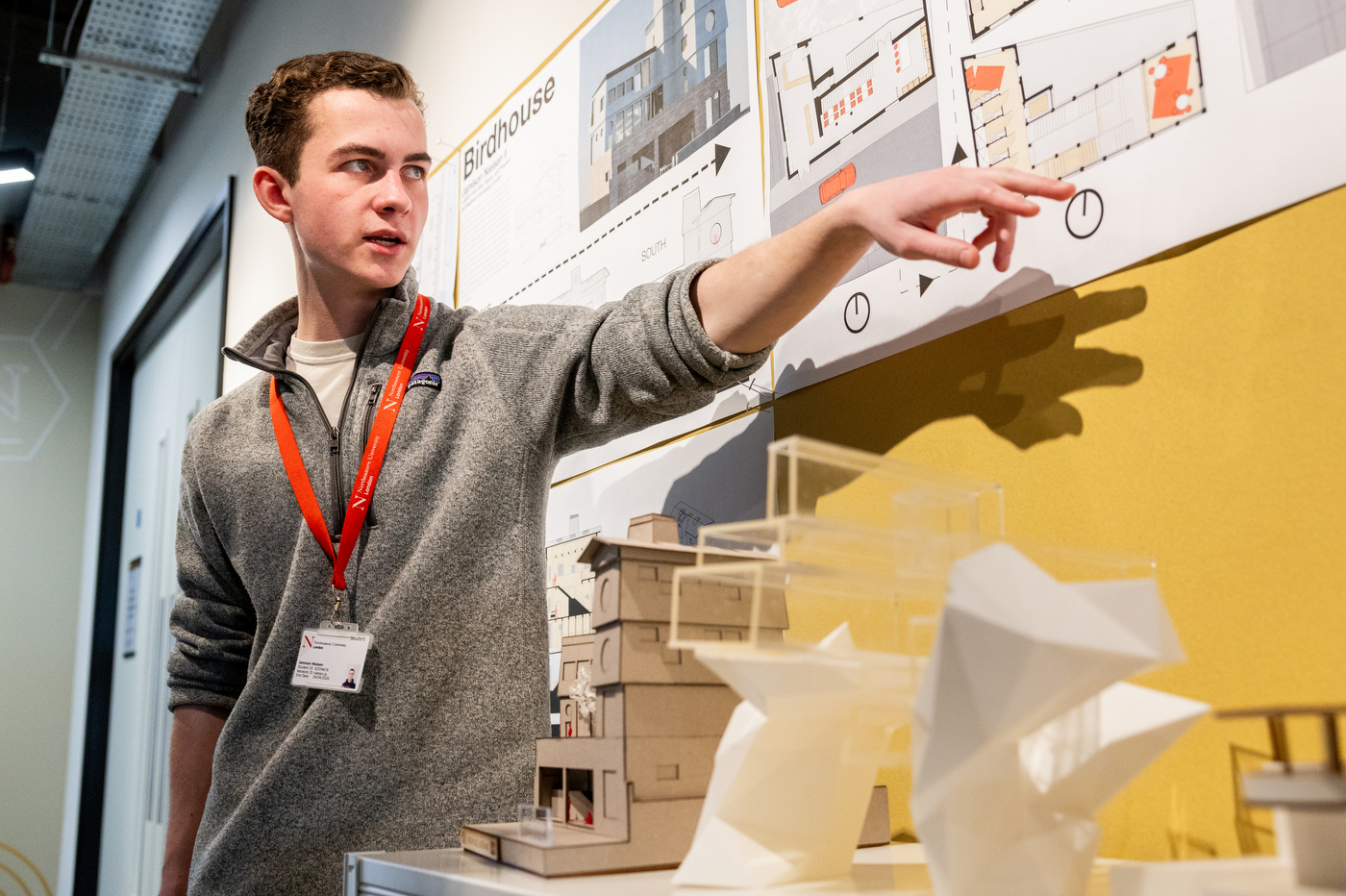 A Northeastern student points to graphics on a chart at the "created at northeastern" student showcase