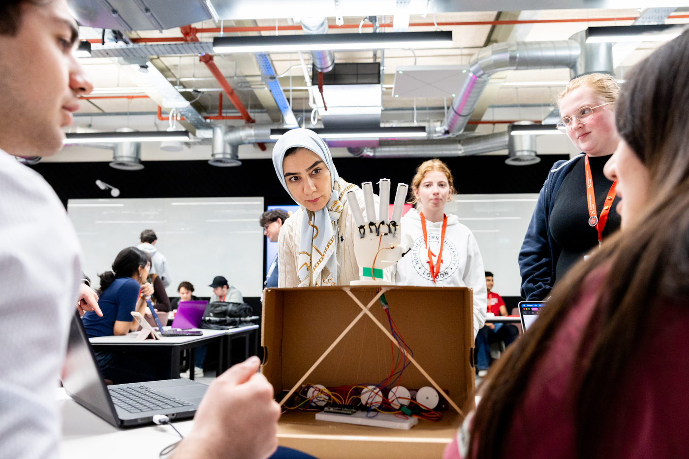 A woman looks at a robotic hand