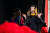 A graduate celebrates as she walks across the stage.
