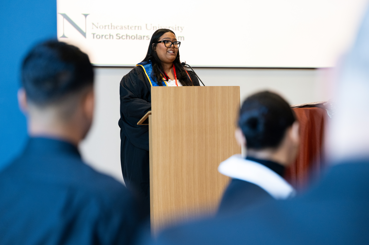 Jessenia Castillo speaks at a podium at the Torch Scholars brunch in the Curry Ballroom.