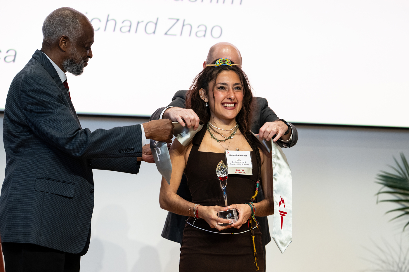 Two people placing a stole around Nicole Pantiledes neck.