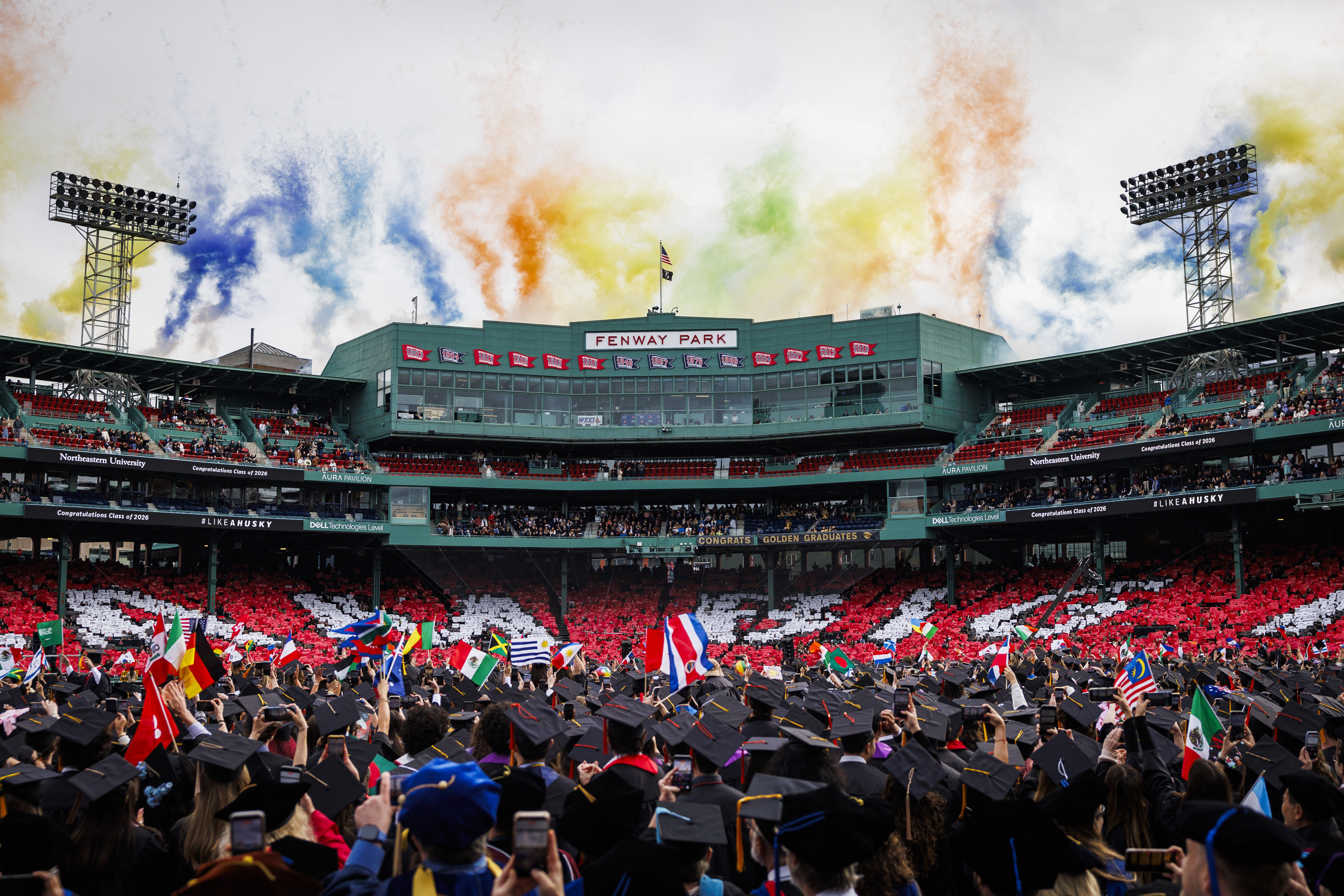 A wide shot of colorful fireworks going off during the commencement finale at Fenway Park.
