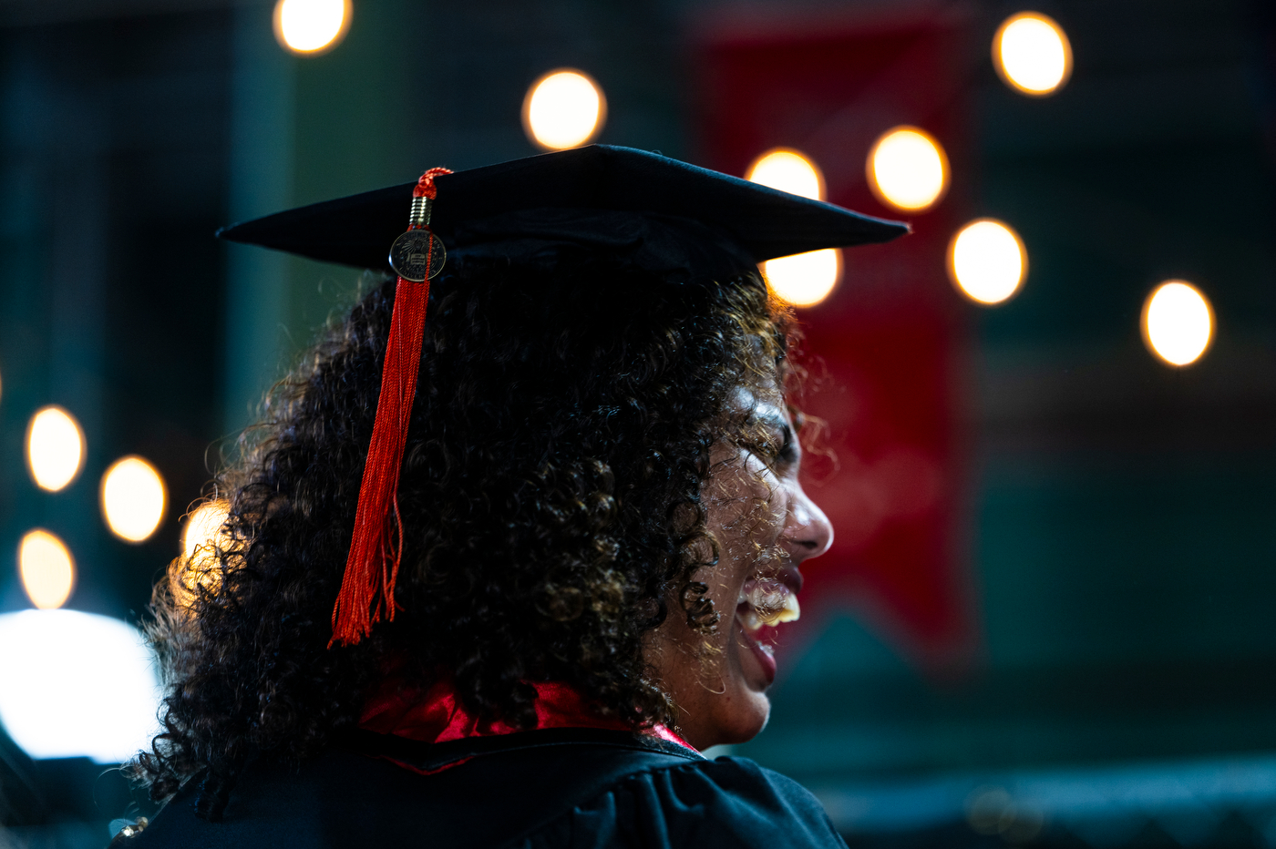 A close up on the profile of a graduate wearing a cap and gown.