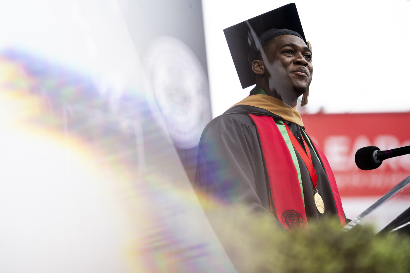 A graduate student speaker speaks at a podium at the graduate ceremony. 
