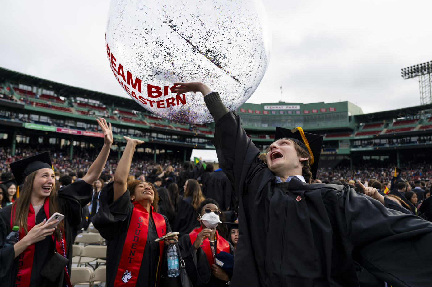 Graduates play with an inflatable ball.