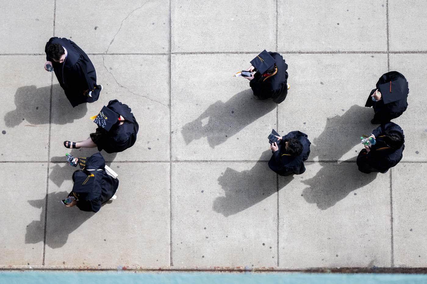 A top down view of graduates on the sidewalk outside Fenway Park.