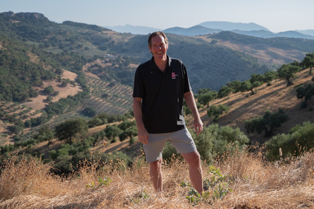 Journalism professor Mike Beaudet stands on a hillside in rural Spain.
