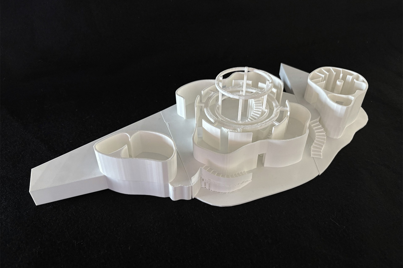 A white architectural model against a black backdrop