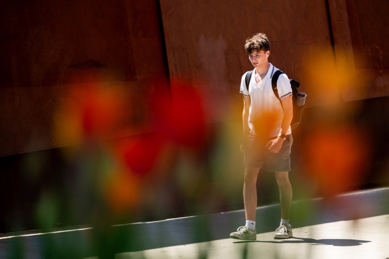A student crosses the pedestrian bridge with colorful blurred camera affects.