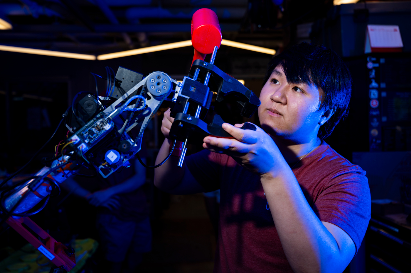 Salem Chen holds robotics parts while working on the mars rover.