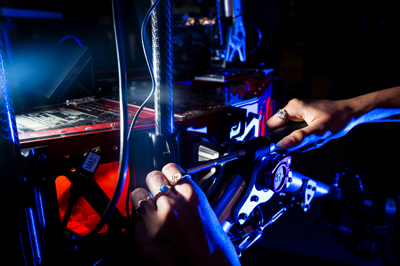 A closeup of Srikeerthi Bhupathuraju's hands working on the team's mars rover machine.