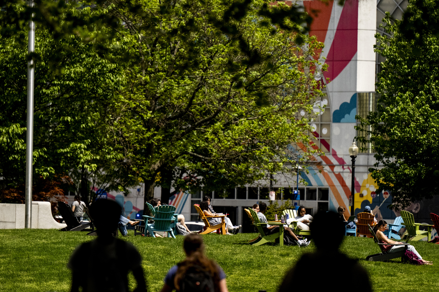 Students sit and lay outside in the Centennial Common.
