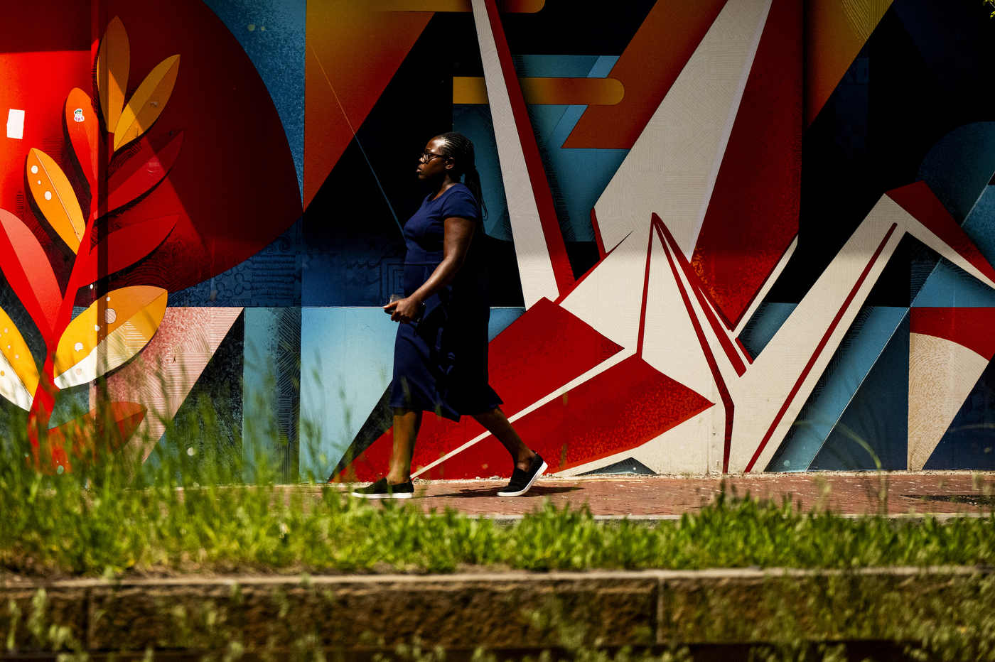 A person walks past a colorful painted mural.