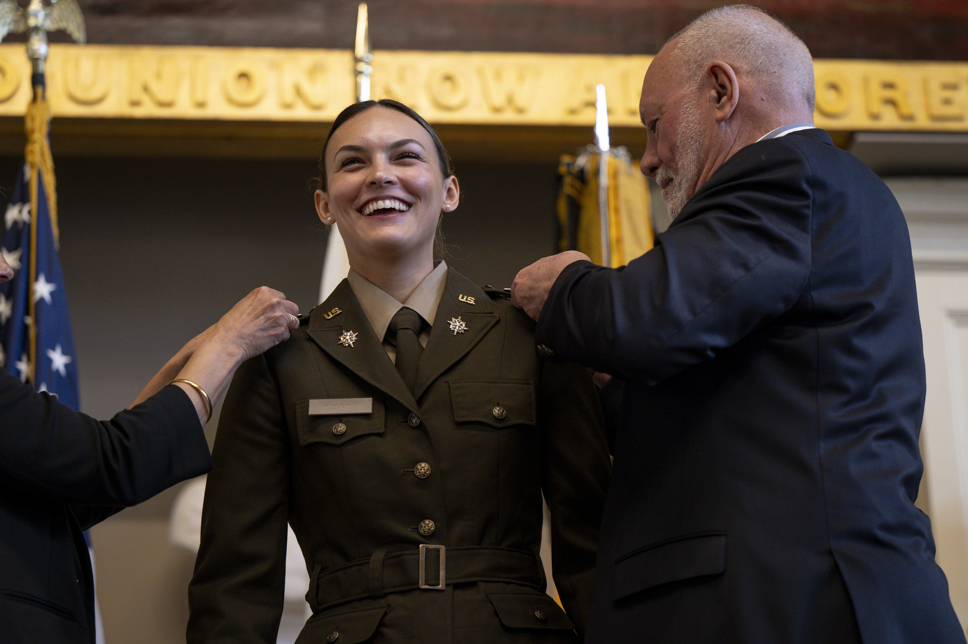 A cade smiles as she receives new additions to her uniform.