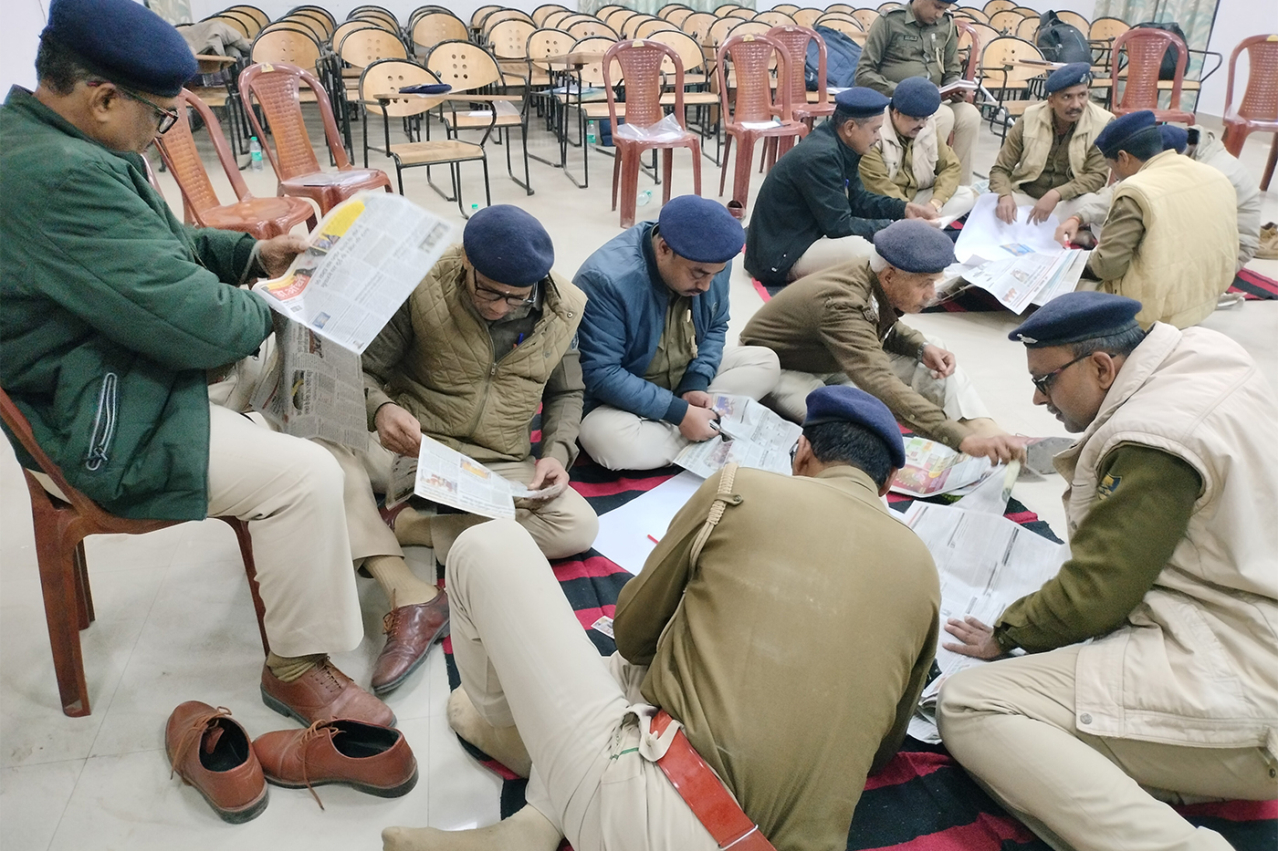 Police officers seated on the floor reviewing documents during a training or training session.