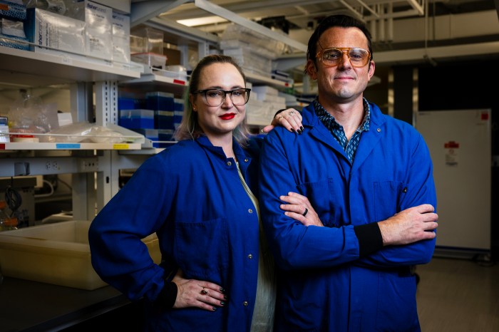 Ryan and Abigail Koppes pose together wearing identical blue protective gear and goggles.