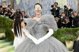 Sarah Paulson at the 2026 Met Gala in a gray tulle ball gown with a large bow, long white gloves, and a dollar bill covering her eyes.