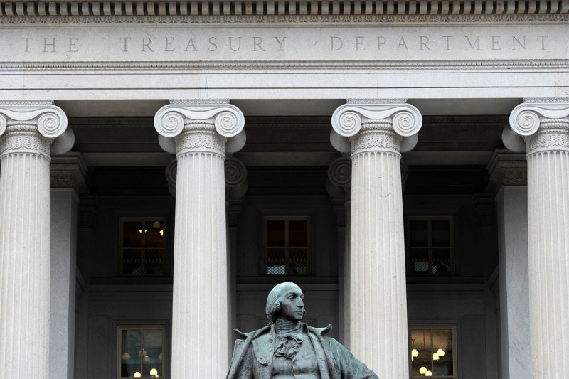 The exterior of the U.S. Treasury Department building in Washington, with a statue in the foreground.