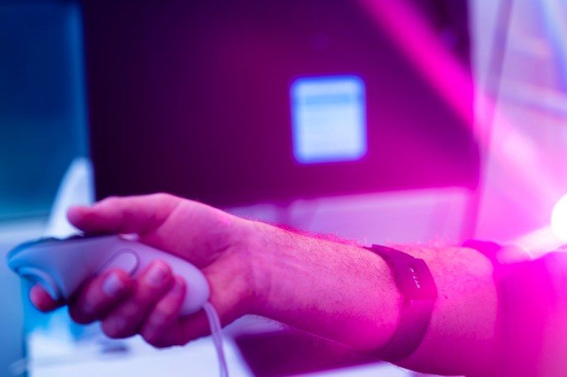 A close up of a Northeastern students hands using a VR control.