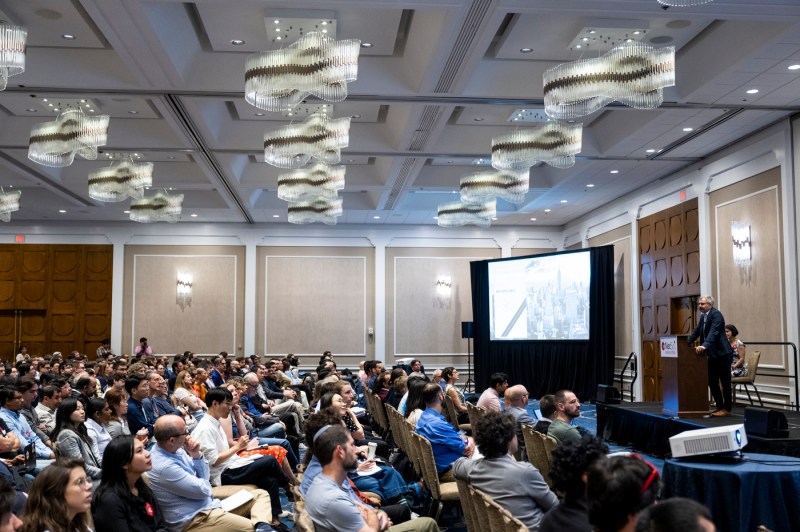 A wide shot of a room full of attendees.