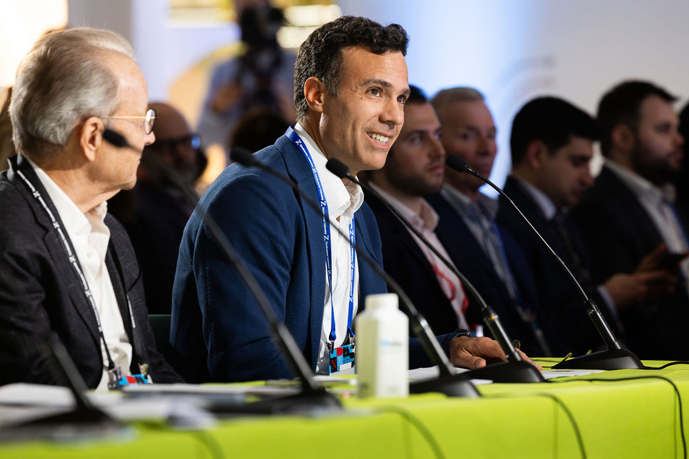 A panel of attendees seated at a table with microphones during a session at the Northeastern Global Leadership Summit in London.