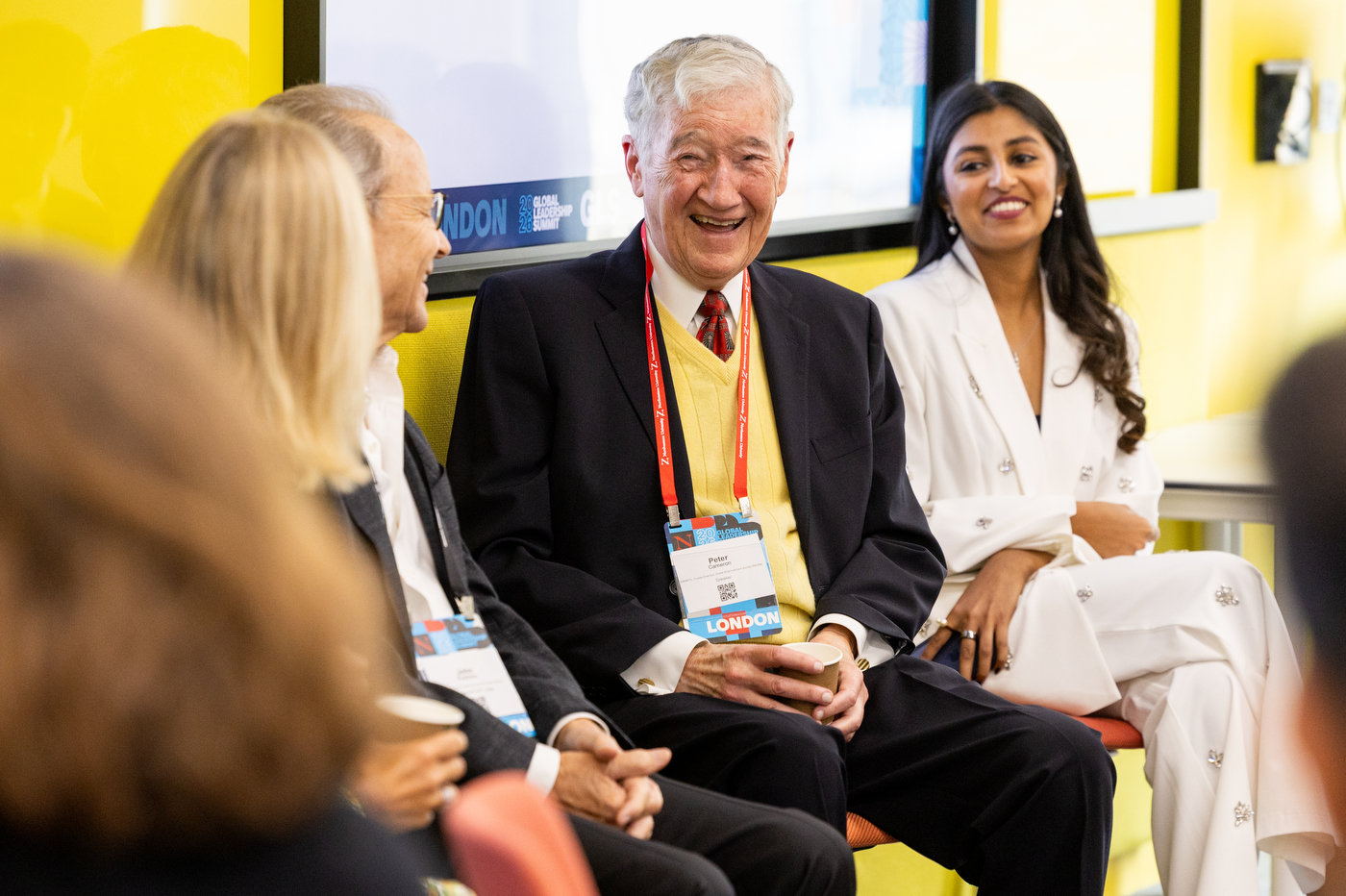 A group of panelists laugh together while sitting on stage at the Global Leadership Summit. 