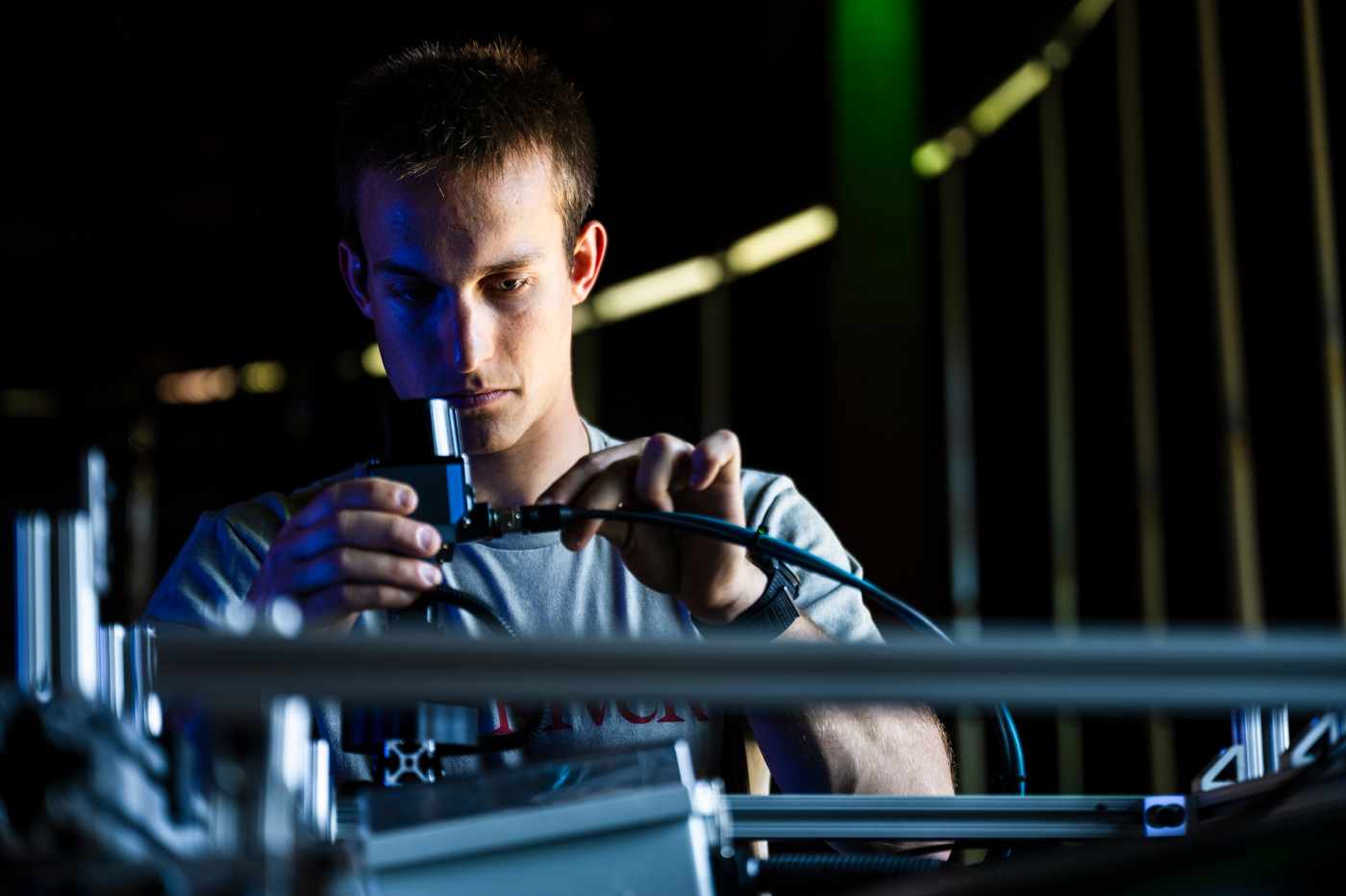 A closeup of a student working on a machine's wiring.