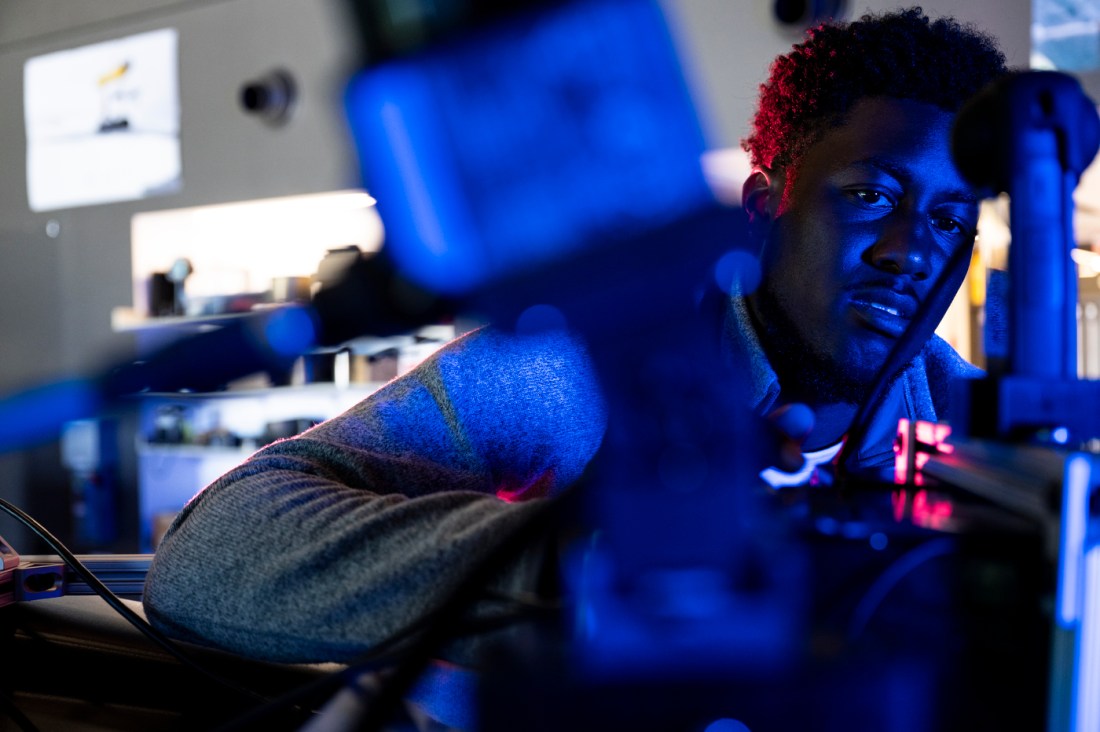 James Tukpah is illuminated by blue light while in a lab setting.