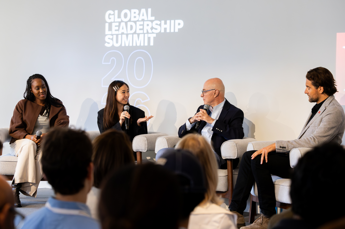 President Aoun speaks with fellow panelists on stage.