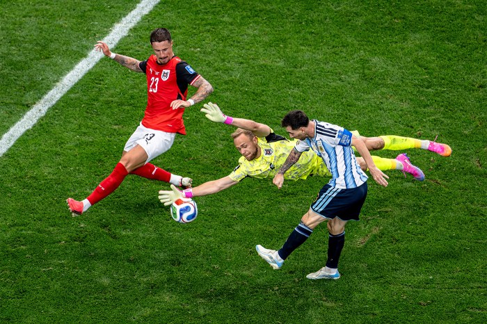 Marco Friedl of Austria, goalkeeper Alexander Schlager of Austria, and Lionel Messi of Argentina go for the ball during a match.