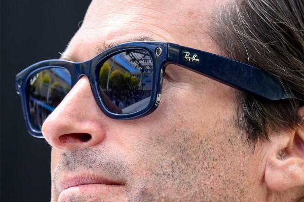 An up-close shot of a person wearing black Ray-Ban smart glasses.