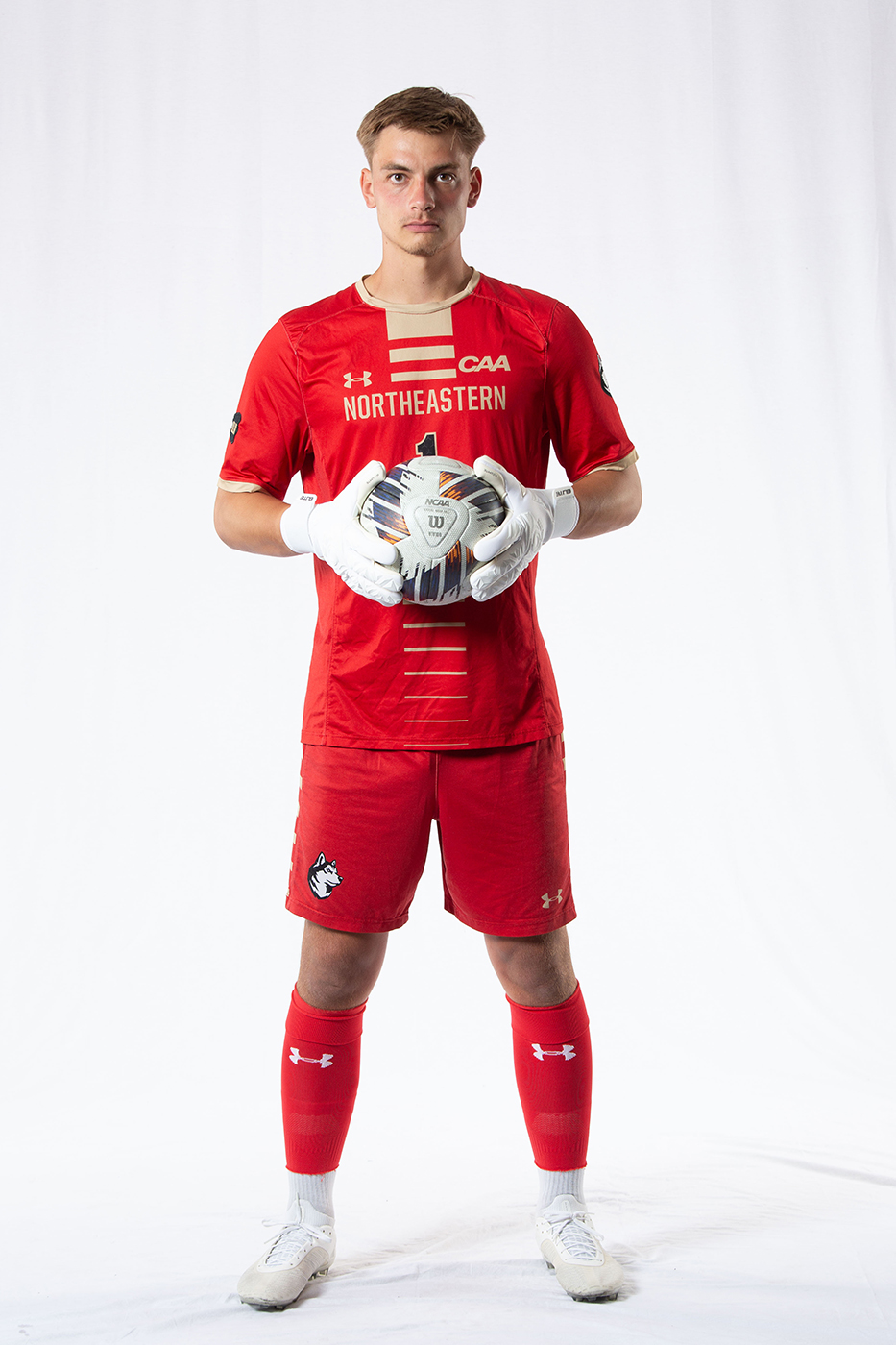 Tobias Jahn, Northeastern University Huskies goalkeeper, in full kit holding a ball during an official team photo.