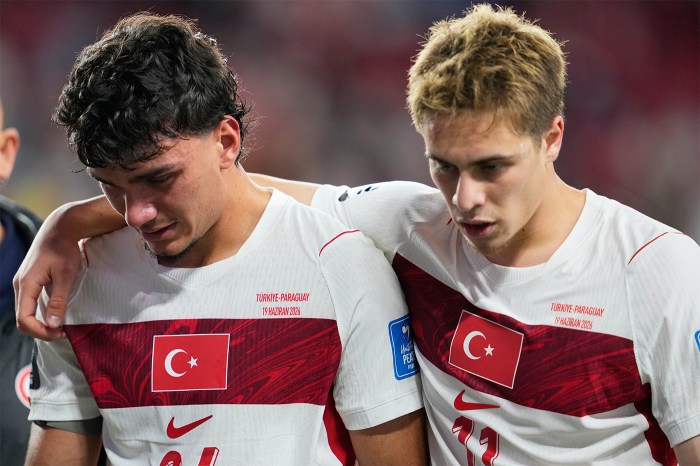 Turkey's Can Uzun, left, and Turkey's Kenan Yildiz hang their heads after a loss against Paraguay.