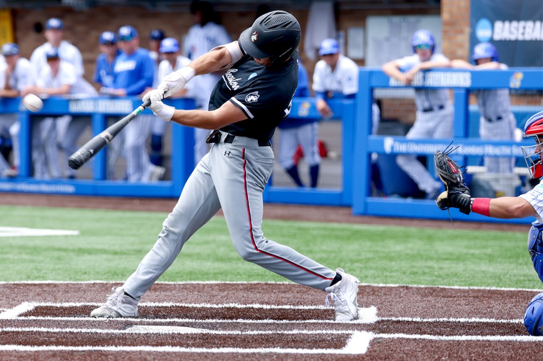 Northeastern baseball player swings at a pitch during the NCAA Tournament.