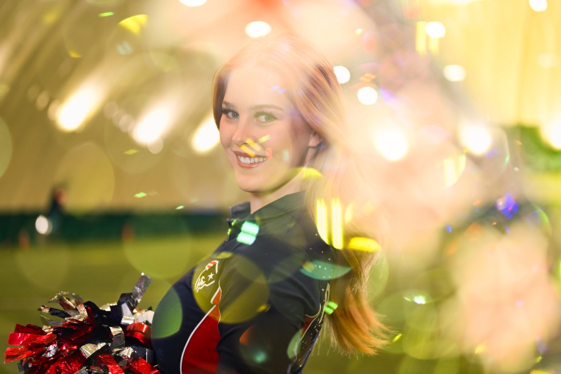 Lana Vogler, a Northeastern behavioral neuroscience and philosophy student and New England Patriots Cheerleader, poses for a portrait with a bokeh effect in the foreground.
