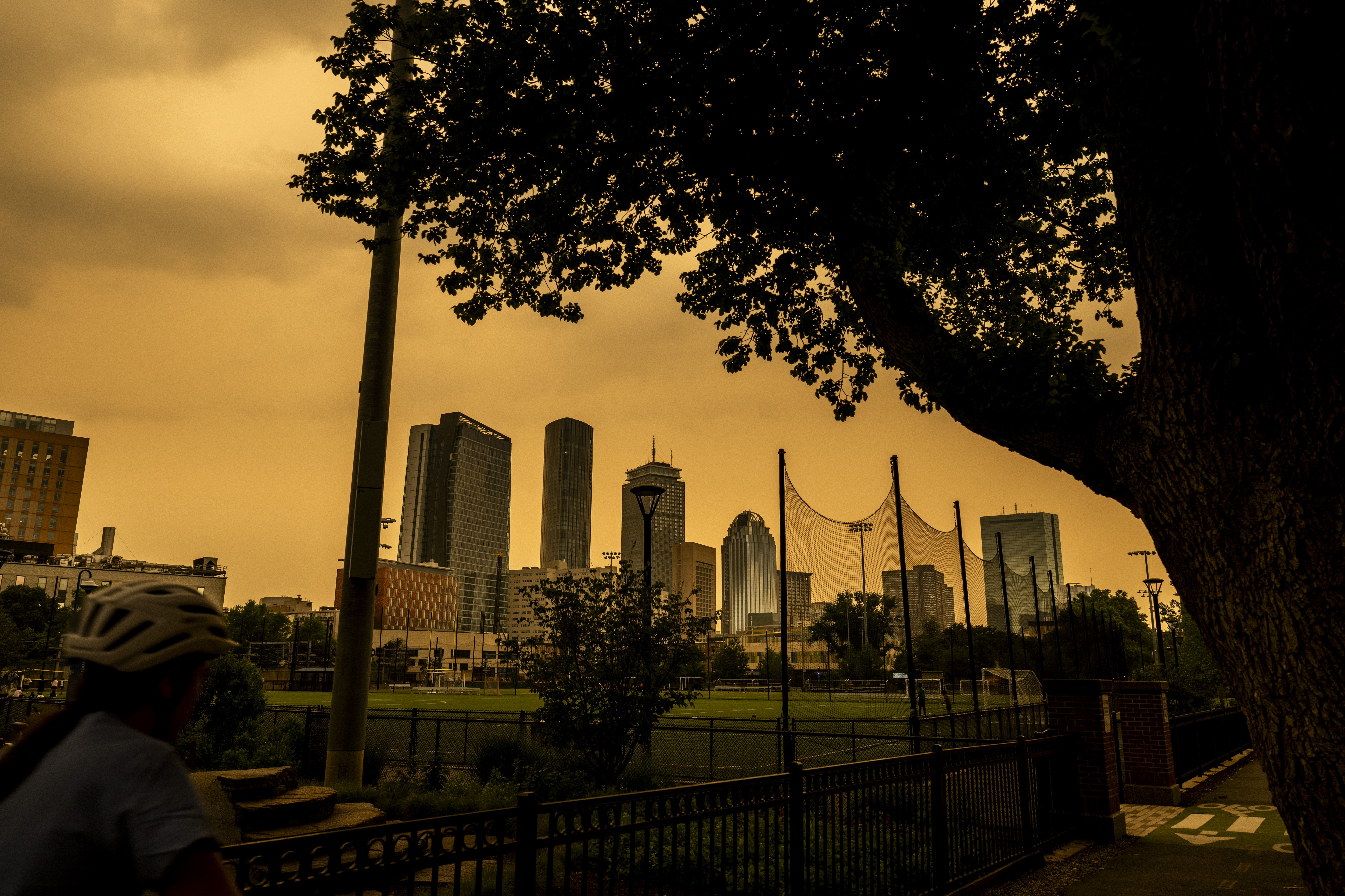 Thick orange haze from wildfire smoke fills the sky over soccer fields.
