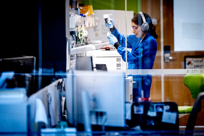 A researcher wearing headphones works with lab equipment inside the Interdisciplinary Science and Engineering Complex.