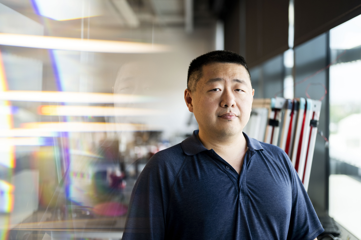 A person poses for a portrait inside of a makerspace.