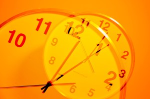 An orange-lit image of a clock superimposed over itself.
